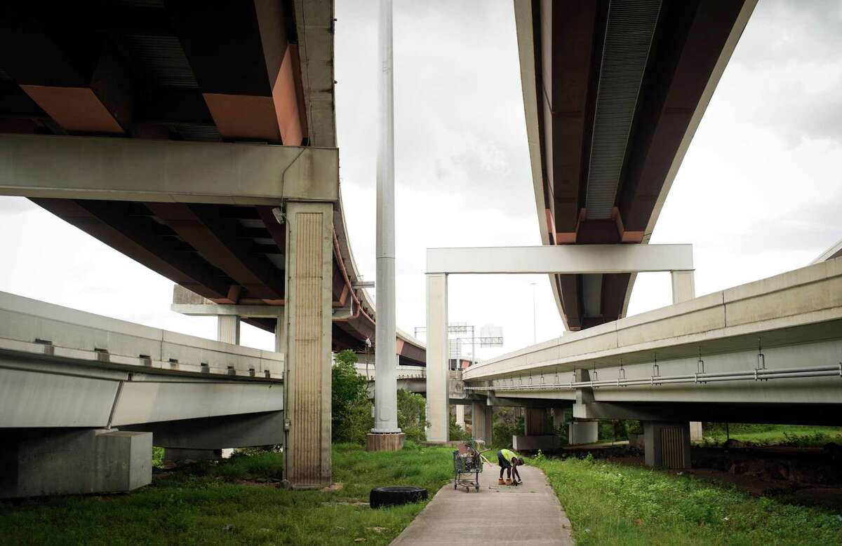 Leon Brown gathers metal beneath Interstate 69 to sell to a scrapyard on Lockwood Drive on July 15, 2022, near Minute Maid Park in Houston. Brown said that he had been told he would need to relocate within a month as work progresses on an expansion of Interstate 45 near downtown.
