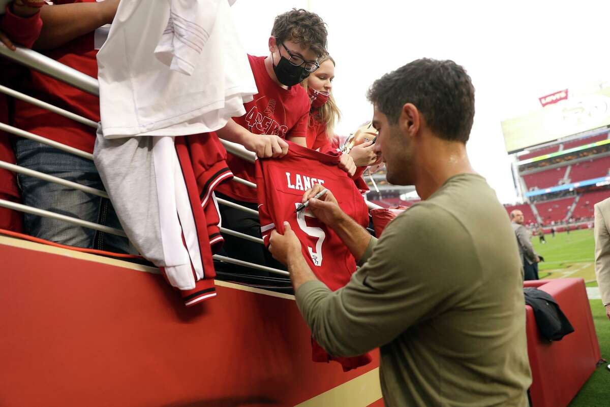 San Francisco 49ers' Jimmy Garoppolo signs a Trey Lance jersey before Niners play Los Angeles Rams during NFL game at Levi's Stadium in Santa Clara, Calif., on Monday, November 15, 2021.