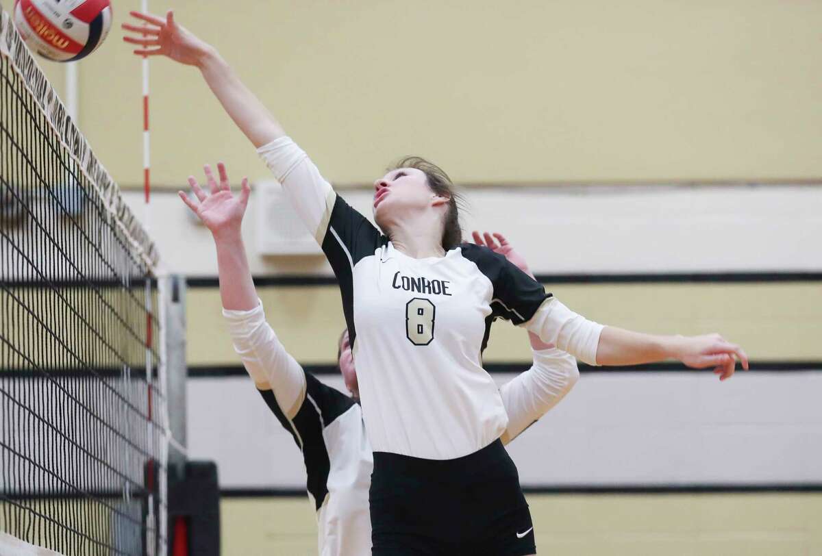 Conroe’s Brooklyn Spikes (8) tips the ball over the net during a District 13-6A high school volleyball match at Conroe High School, Tuesday, Aug. 30, 2022, in Conroe.