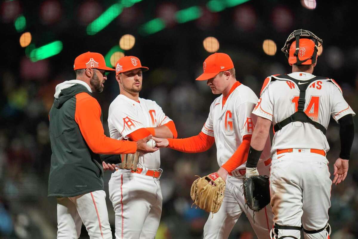 San Francisco Giants starting pitcher Logan Webb, second from right, is pulled from the team's baseball game against the San Diego Padres by manager Gabe Kapler, left, during the sixth inning in San Francisco, Tuesday, Aug. 30, 2022. (AP Photo/Godofredo A. Vásquez)