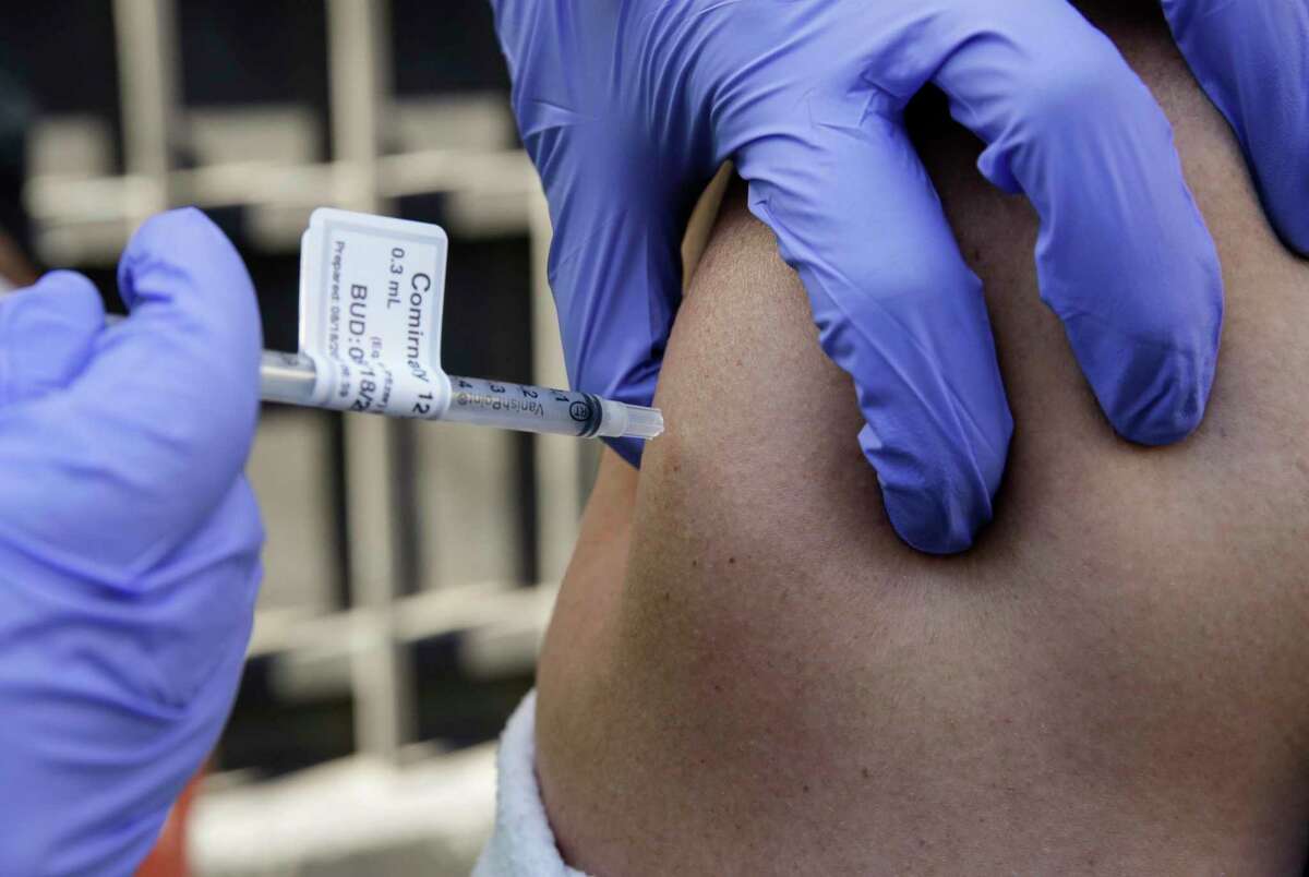 UCSF nurse Nicole Parks delivers a coronavirus vaccine as part of a roving medical team with the community vaccine efforts administer coronavirus vaccines to people in the Tenderloin in San Francisco, Calif. on Thursday, Aug. 18, 2022.