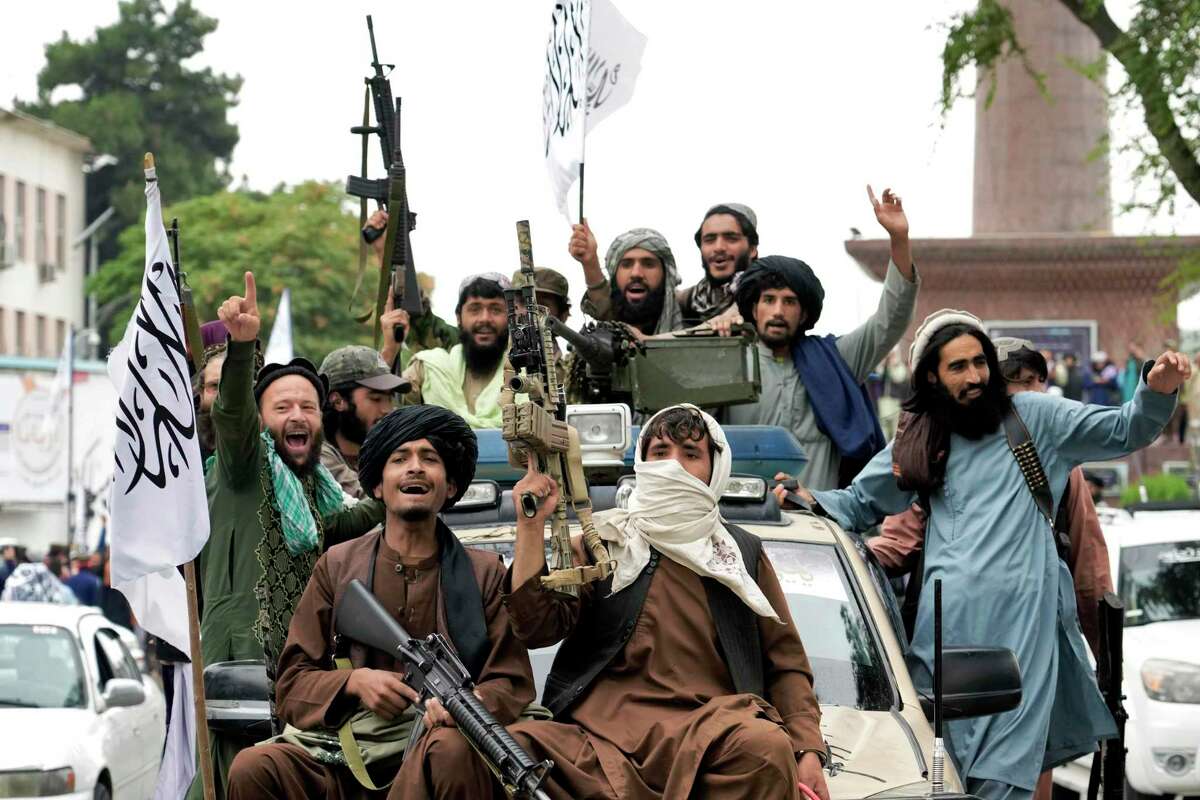The war in Afghanistan came at immense cost, and so did the war’s end. Under the Taliban, human rights have eroded, and an estimated 95 percent of Afghans aren’t getting enough to eat. Here, Taliban fighters celebrate a year ago outside the U.S. embassy in Kabul.