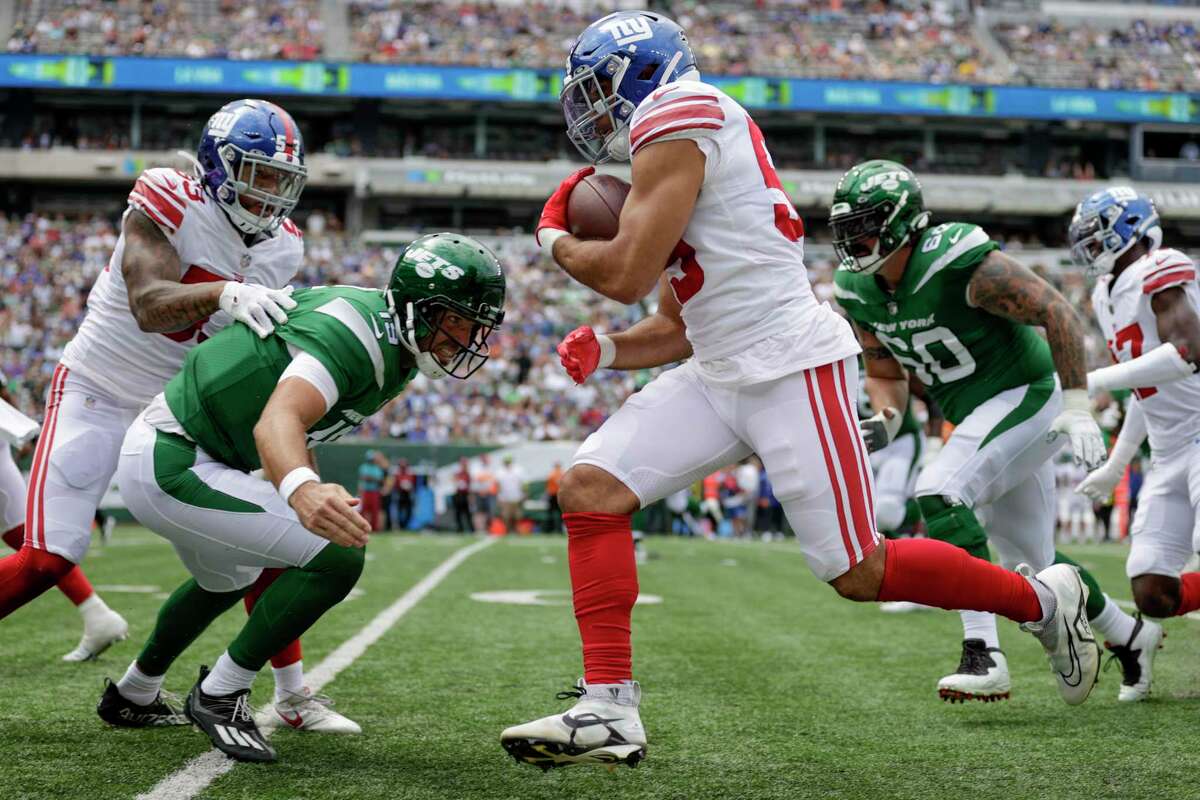 New York Giants linebacker Austin Calitro (59) returns an interception for a touchdown off New York Jets quarterback Joe Flacco (19) in the first half of a preseason NFL football game, Sunday, Aug. 28, 2022, in East Rutherford, N.J. (AP Photo/Adam Hunger)