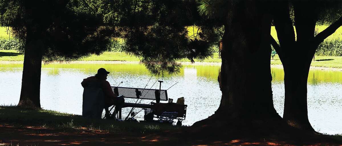 John Badman|The Telegraph A man using one of the benches around the lake in Glazebrook Park in Godfrey enjoyed the solitude of quiet fishing Wednesday.