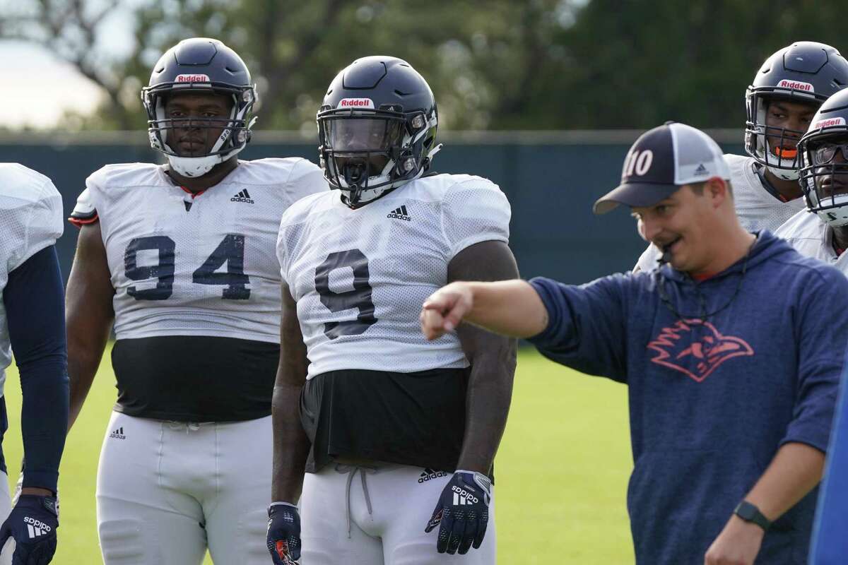 UTSA's Joe Evans (94) and Brandon Brown (9) listen to a coach during practice Thursday morning at the Roadrunner Athletics Center of Excellence.