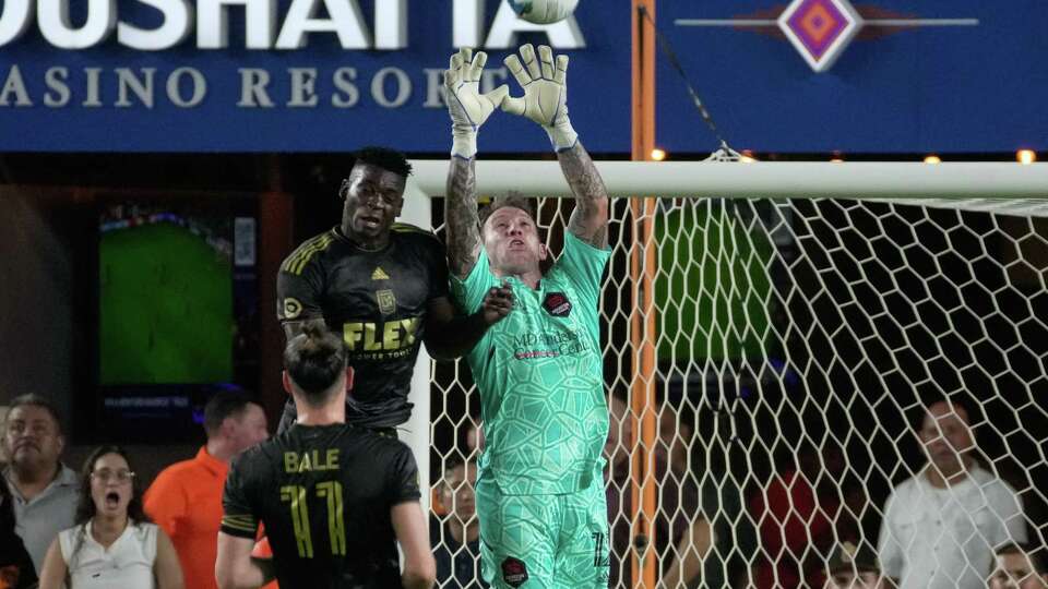 Houston Dynamo goalkeeper Steve Clark (12) attempts to catch a shot while Los Angeles FC defender Jesús Murillo (3) is ttrying to score during the second half of a MLS game Wednesday, Aug. 31, 2022, at PNC Stadium in Houston. Houston Dynamo defeated Los Angeles FC 2-1.