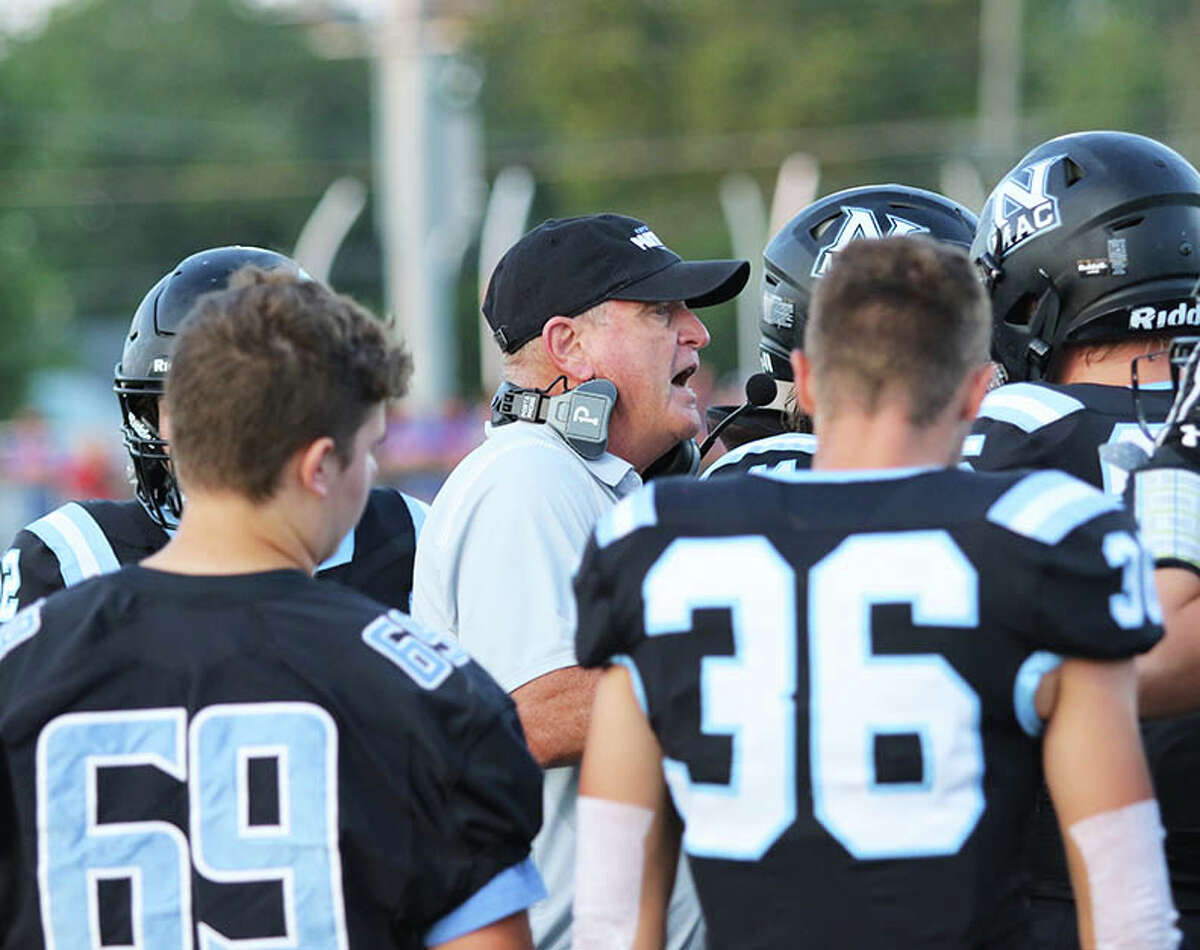 North Mac assistant coach Dan Bowman (middle) talks with the Panthers defense during a timeout against Carlinville in a Week 1 SCC football game in Virden.