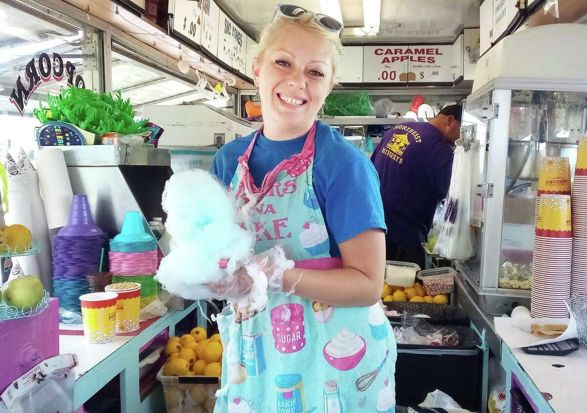 The Haddam Neck Fair, which takes place over the Labor Day weekend at the fairgrounds in Haddam, Friday through Monday, is back for the 110th year. Here, a vendor shows off blue cotton candy at last year’s event.