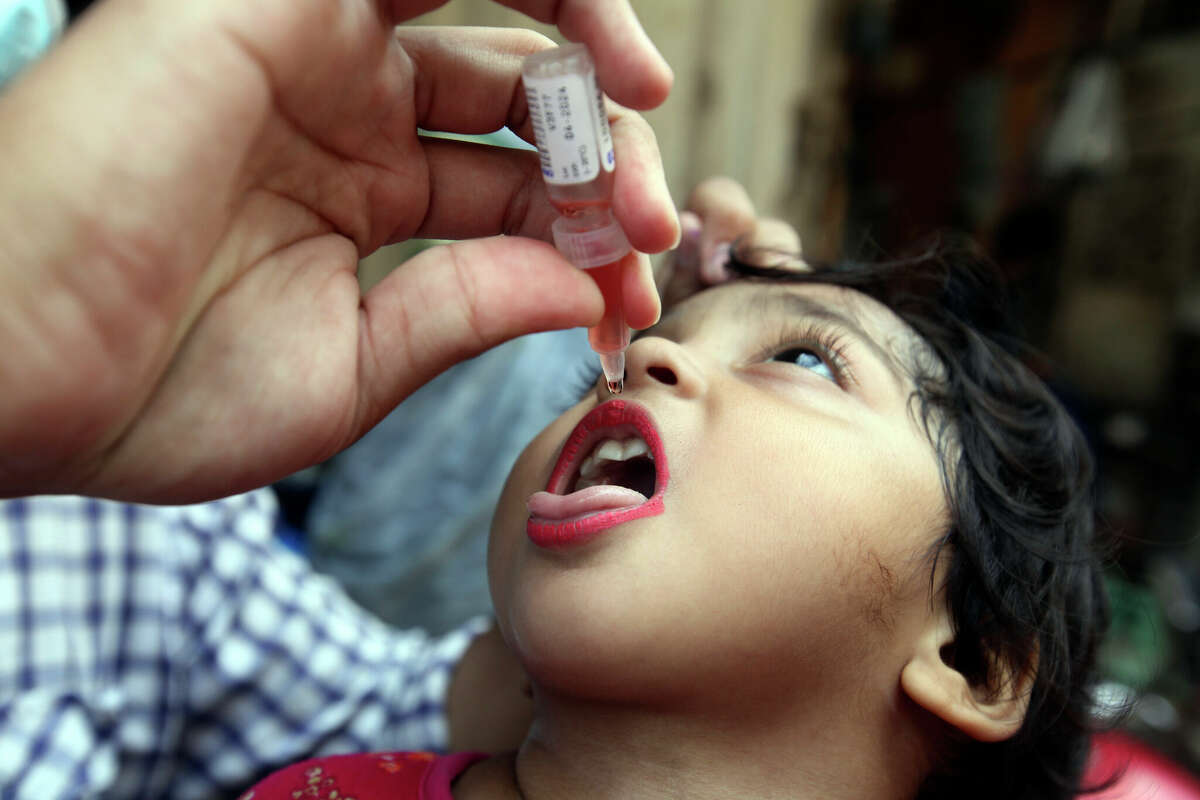 A health worker administers a polio vaccine to a child in Lahore, Pakistan, Monday, Aug. 22, 2022. 