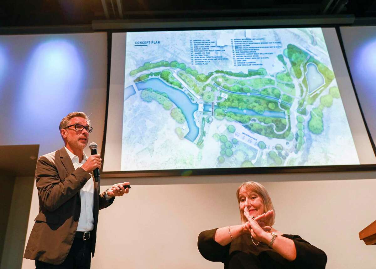 Kinder Baumgardener, left, of the SWC Design Group, explains new features during the seventh Brackenridge Park 2017-2022 bond project public meeting at the Witte on Wednesday, Aug. 31, 2022. City parks and public works officials presented the latest plan for the controversial 2017-2022 Brackenridge Park bond project, which includes removal of trees and added greenspace on the northern end of the park. A sign language interpreter signals his speech.