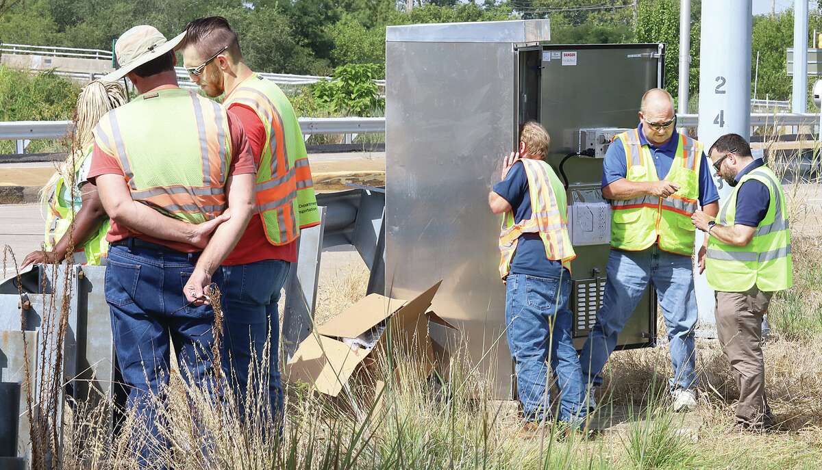 John Badman|The Telegraph Employees of Wissehr Electrical Contractors and Illinois Depaartment of Transportation work to set up a new traffic control signal box near an Alton intersection on Thursday.