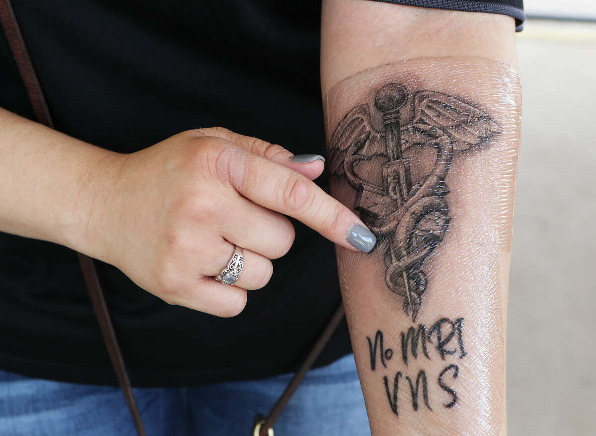 U.S. Army veteran Marcey Phillips points out a new tattoo which informs medical providers not to give her an MRI because of her vagus nerve stimulation, Thursday, Sept. 1, 2022, in Conroe. Phillips was recently honored for her dedication to her country and community by the VFWâs #StillServing campaign, which recognizes veterans who continue to serve in the community after the military. Phillips developed epilepsy during her time serving in the Iraq War and got her America black labrador two years ago to help wake Phillips from nightmares, deal with crowds or help detect seizures. Phillips said she is #StillServing because âit is heartwarming to see people change their understanding of service dogs and I love seeing the faces of veterans, kids and the elderly light up when Beignet and I visit.â