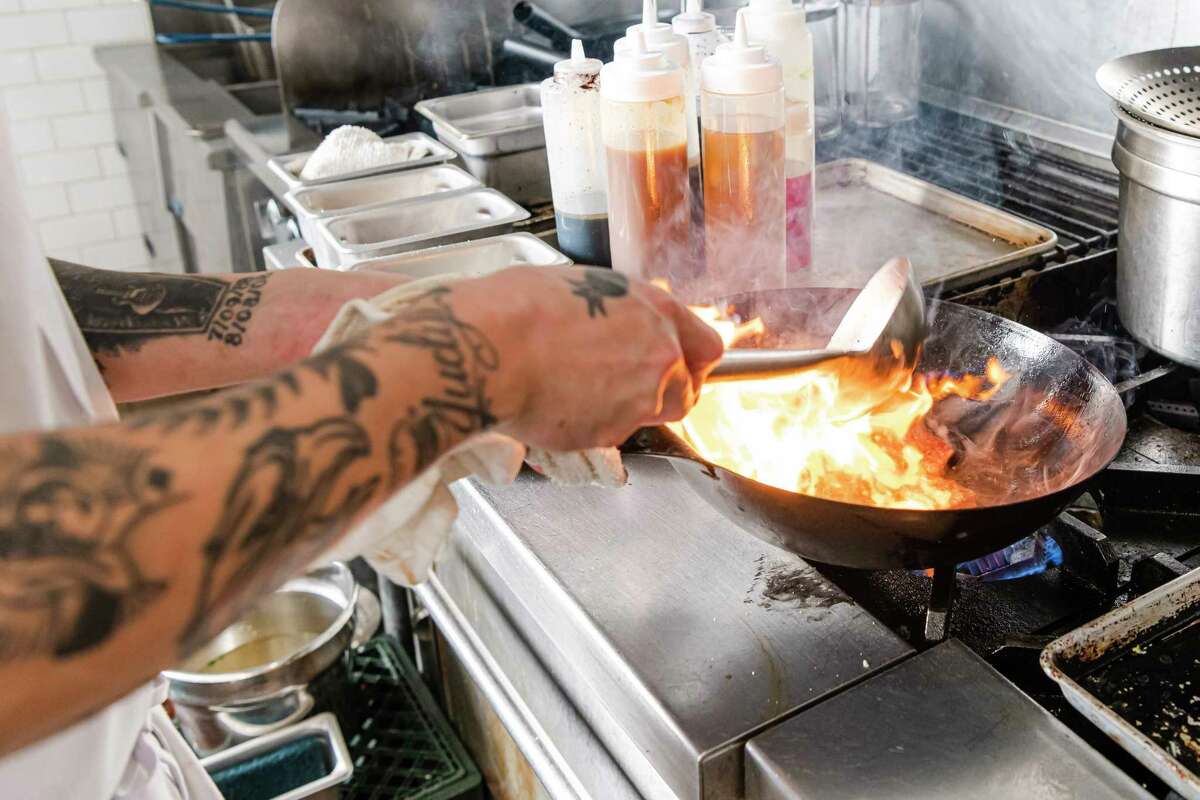 In the kitchen at San Francisco's Lazy Susan, which is dropping menu prices in September.