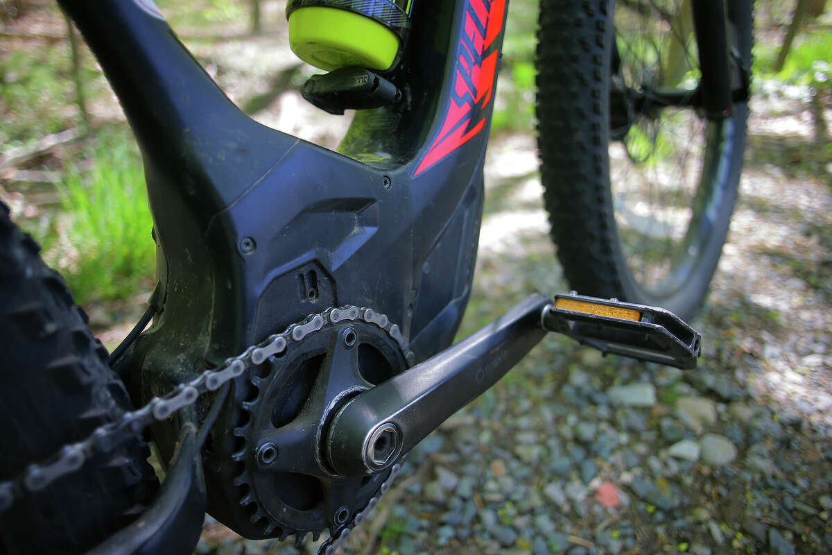 The enlarged bottom bracket area that houses the motor of the e-bike. E-bikes are pedal-assisted bikes that have generated controversy, as they potentially threaten to disrupt access to nonmotorized trails for mountain biking.