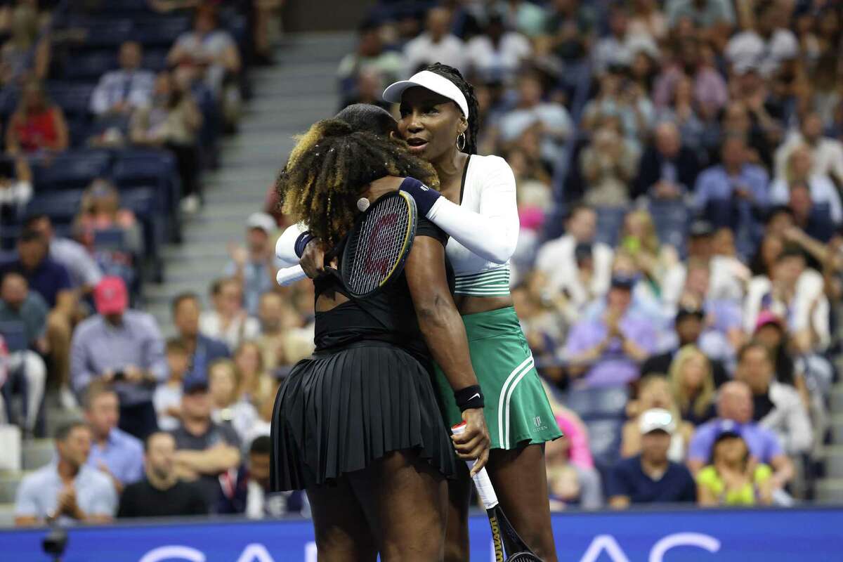 Serena and Venus Williams embrace after being defeated by the Czech pairing of Lucie Hradecka and Linda Noskova during a U.S. Open first-round doubles match in New York.