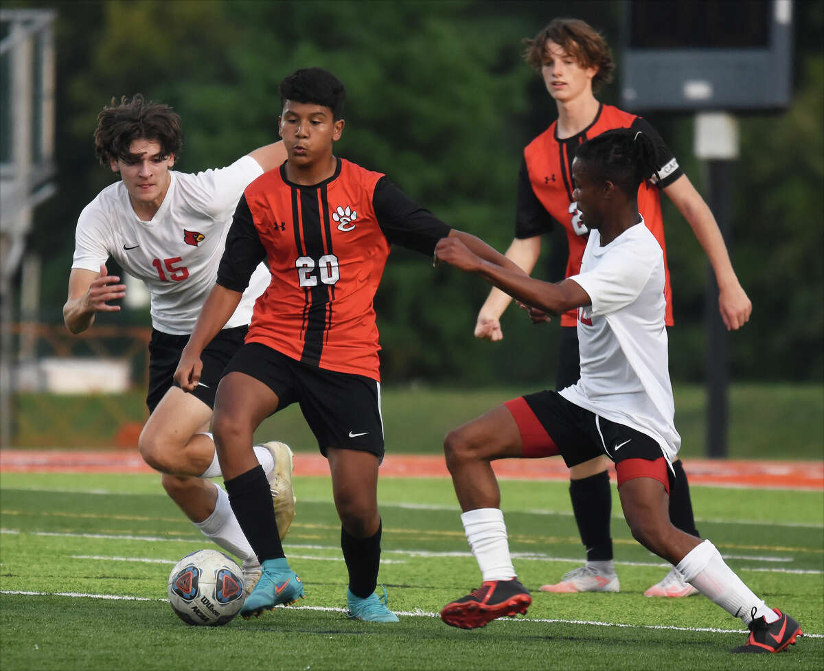 Edwardsville's Brian Salazar splits Alton's Ashton Schepers, left, and Jude Runyon, right, during Thursday's Southwestern Conference game inside the District 7 Sports Complex in Edwardsville.