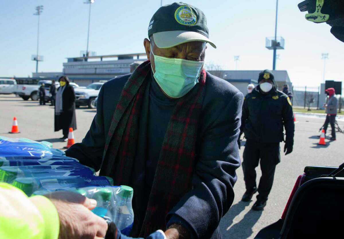Houston Mayor Sylvester Turner helps distributing free bottled water at a mass distribution Friday, Feb. 19, 2021, at Delmar Stadium in Houston.