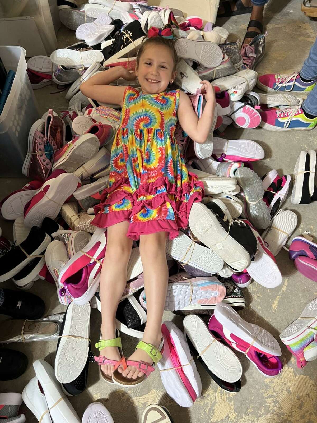 Thomas, 5, takes a break from her volunteer duties at sole Mission to have some fun in the shoes. Makynlee volunteers to help others in many ways.