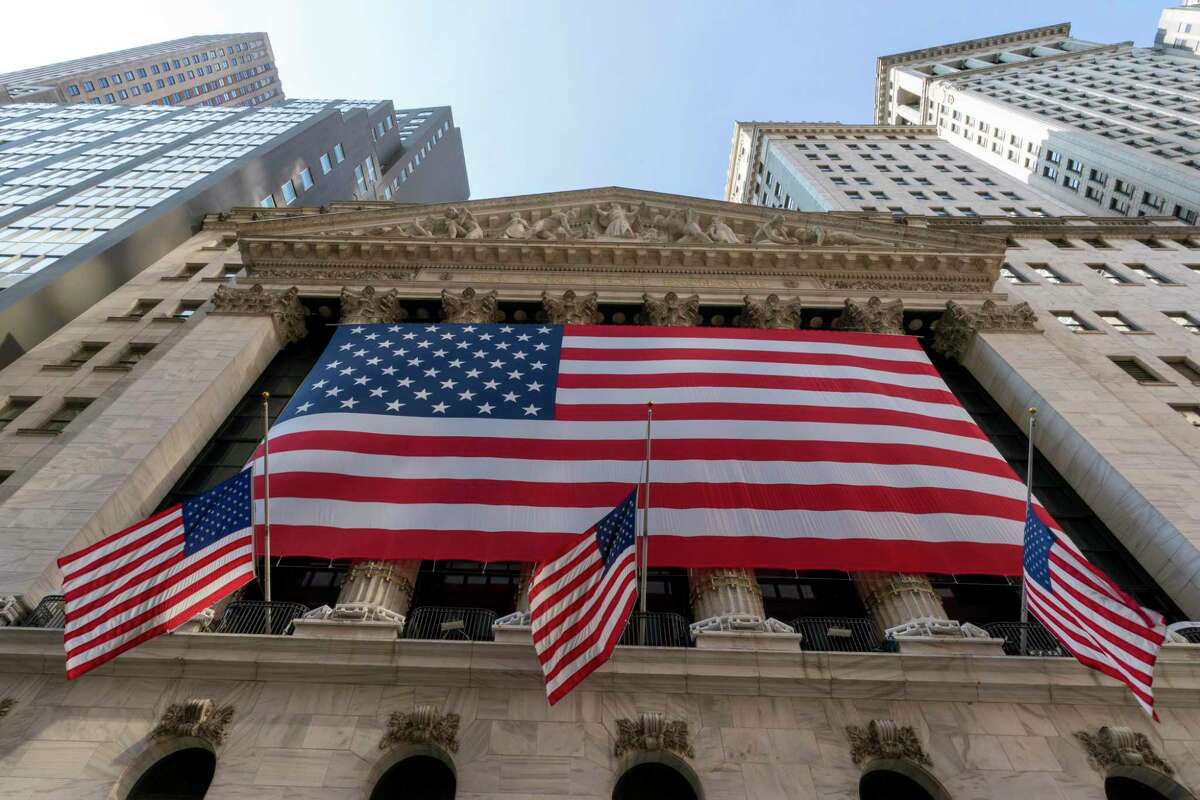FILE - In this Monday, Sept. 21, 2020, file photo, a giant American Flag hangs on the New York Stock Exchange. U.S. stocks are climbing Monday, Nov. 2, 2020, kicking off a potentially turbulent stretch for markets, as Wall Street recovers some of its sharp sell-off from last week. (AP Photo/Mary Altaffer, File)