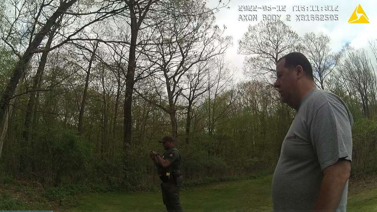 A screenshot from body camera footage taken by a Newtown police officer shows off-duty Ridgefield police officer, Lawrence Clarke and an officer with the state’s Department of Energy and Environmental Protection in the hours after Clarke shot and killed a black bear outside his Newtown home.