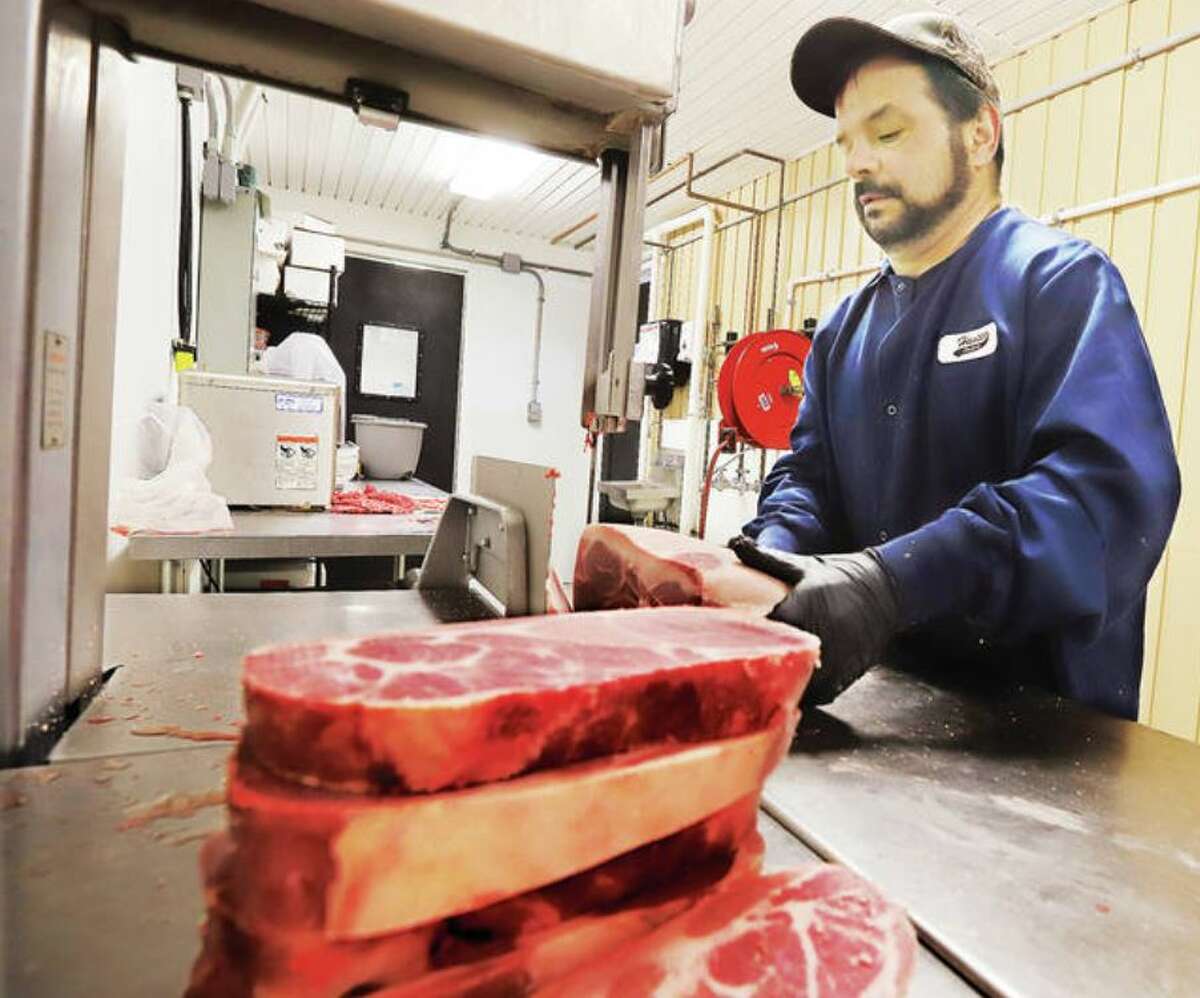 Ryan Hansen of Hansen Meat Co. in Alton and Hansen Packing in Jerseyville prepares cuts in this file photo. Both Hansen and Ian Warford at the Godfrey Meat Market said current prices are comparable to the 4th of July and Memorial Day weekend earlier this year.