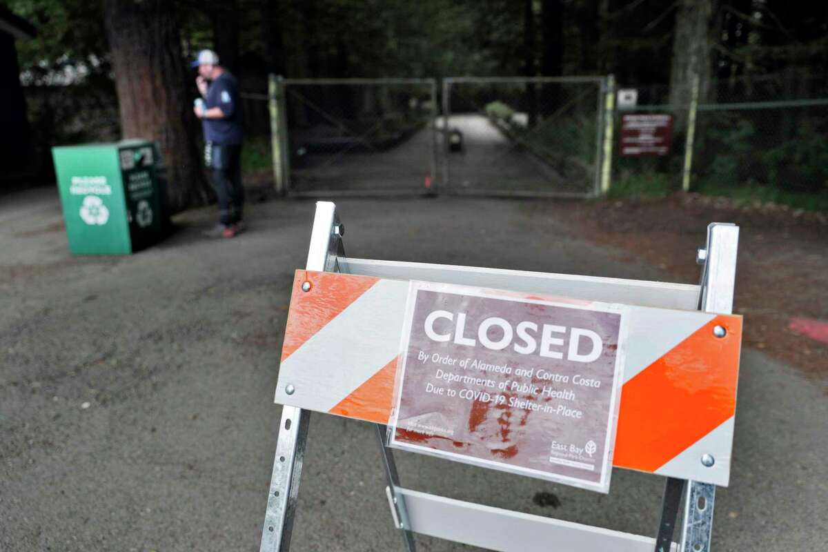 A sign informs visitors at Tilden Regional Park that facilities are closed as people get out of their homes during the statewide shelter in place in Berkeley in March 2020. Tilden and dozens of other East Bay Parks were closing down to prevent people from roaming through them during the coming heat wave.