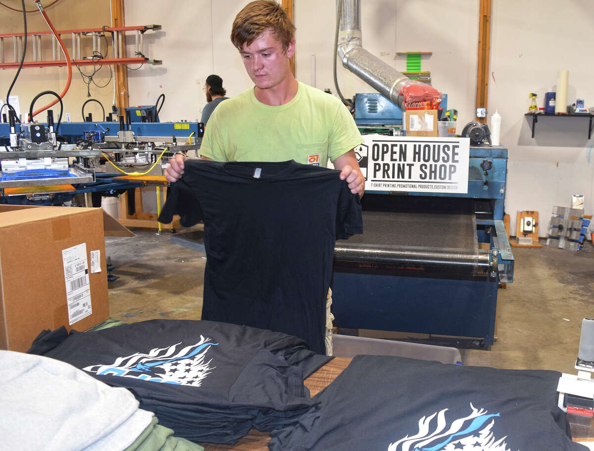 Brayton Smith prepares a T-shirt order for the South Jacksonville Police Department at Open House Print Shop.