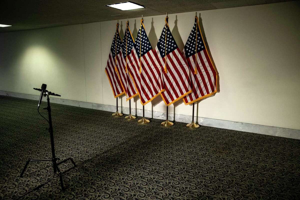 Flags and a microphone set up before a Republican luncheon in Washington, Oct. 25, 2020. If Republicans and Democrats go to the extremes in selecting their 2024 presidential candidate, there will be a third viable option, a unity ticket, which will appeal to members of both parties to combat this period of polarized dysfunction, the New York Times opinion columnist David Brooks writes.