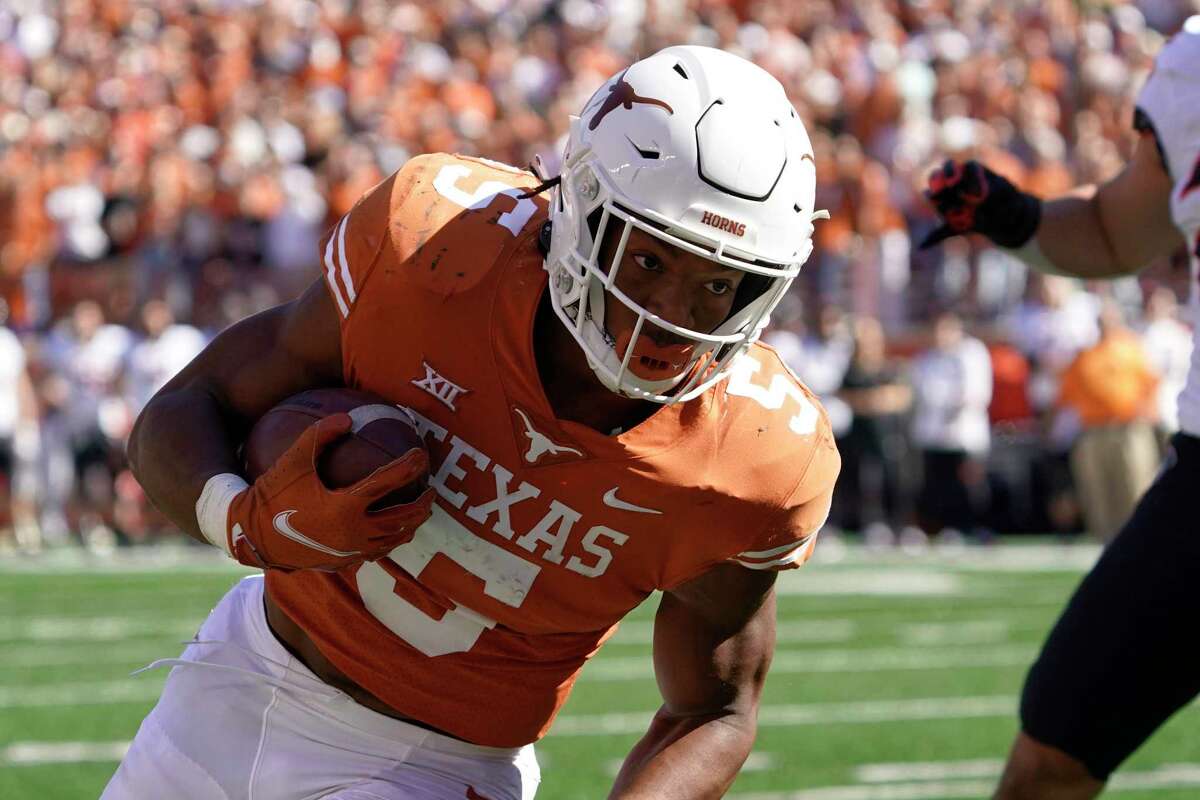 FILE - Texas running back Bijan Robinson (5) runs against Oklahoma State during the first half of an NCAA college football game in Austin, Texas, Saturday, Oct. 16, 2021. The Big 12 will begin its 27th season this week with some uncertainty of what will stand out offensively since there are three new head coaches and plenty of different skill players. (AP Photo/Chuck Burton, File)