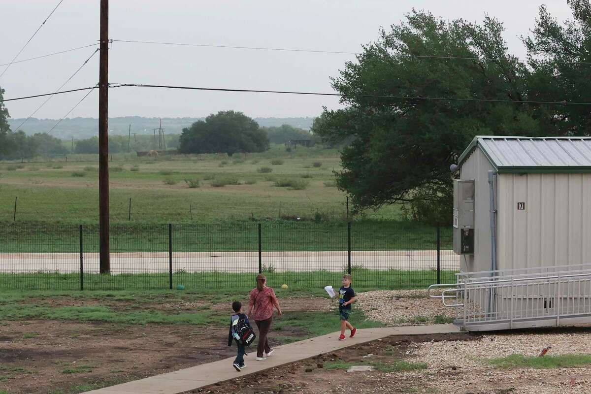 Students are escorted to their portable building classrooms at East Central ISD’s Tradition Elementary School on Wednesday. The school has more than 925 students and had to add portables less than four years after it opened. Rapid subdivision growth has pushed the district to call for a $240 million bond election, though a similar effort failed last year.