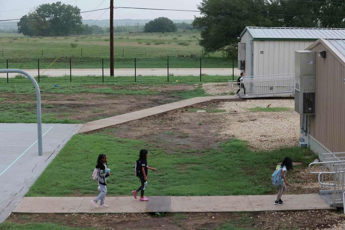 Students walk to their classrooms in portable buildings at East Central ISD’s Tradition Elementary School on Wednesday. The school has more than 925 students and had to add portables less than four years after it opened. Rapid subdivision growth has pushed the district to call for a $240 million bond election, though a similar effort failed last year.