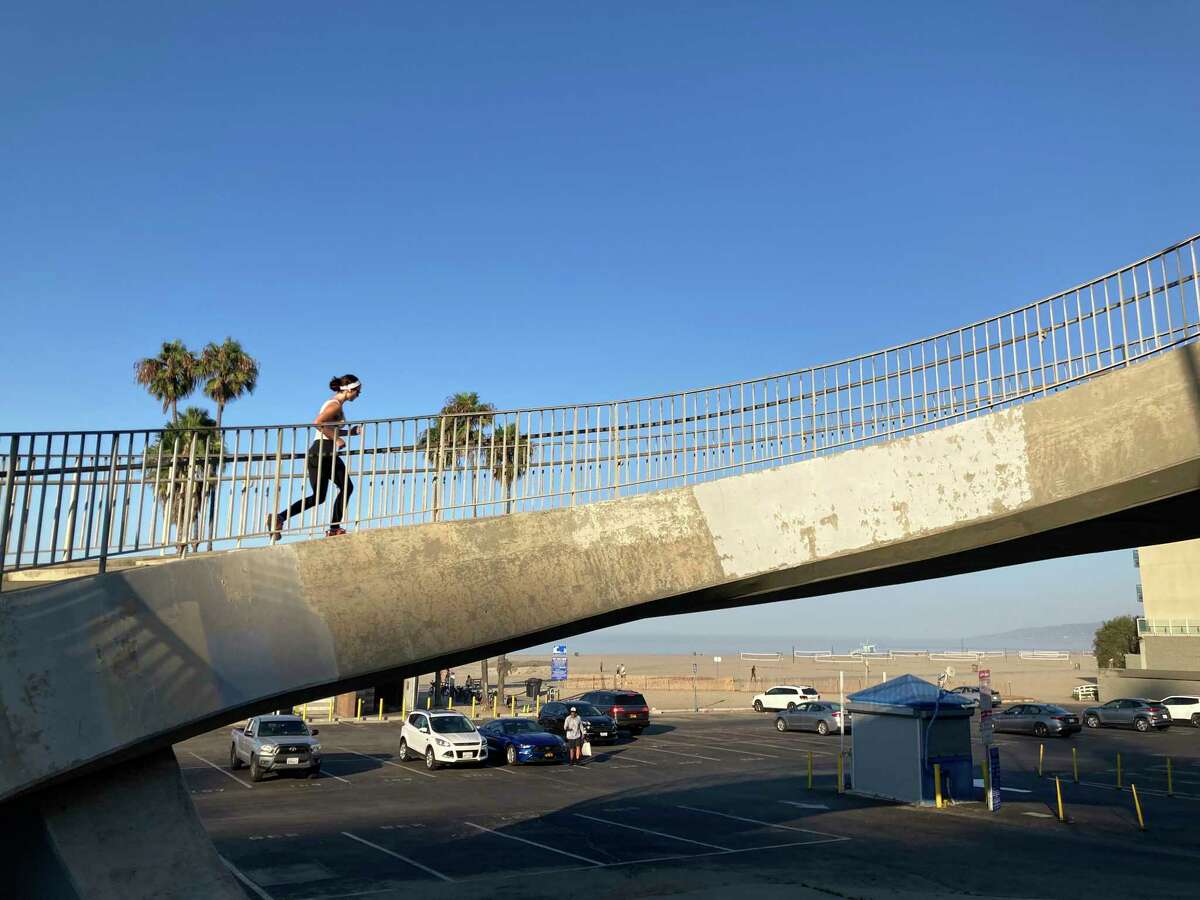 RETRAMISSION TO CORRECT YEAR TO 2022 - A jogger runs over an overpass near Pacific Coast Highway on a hot morning Friday, Sept. 2, 2022 in Santa Monica, Calif.