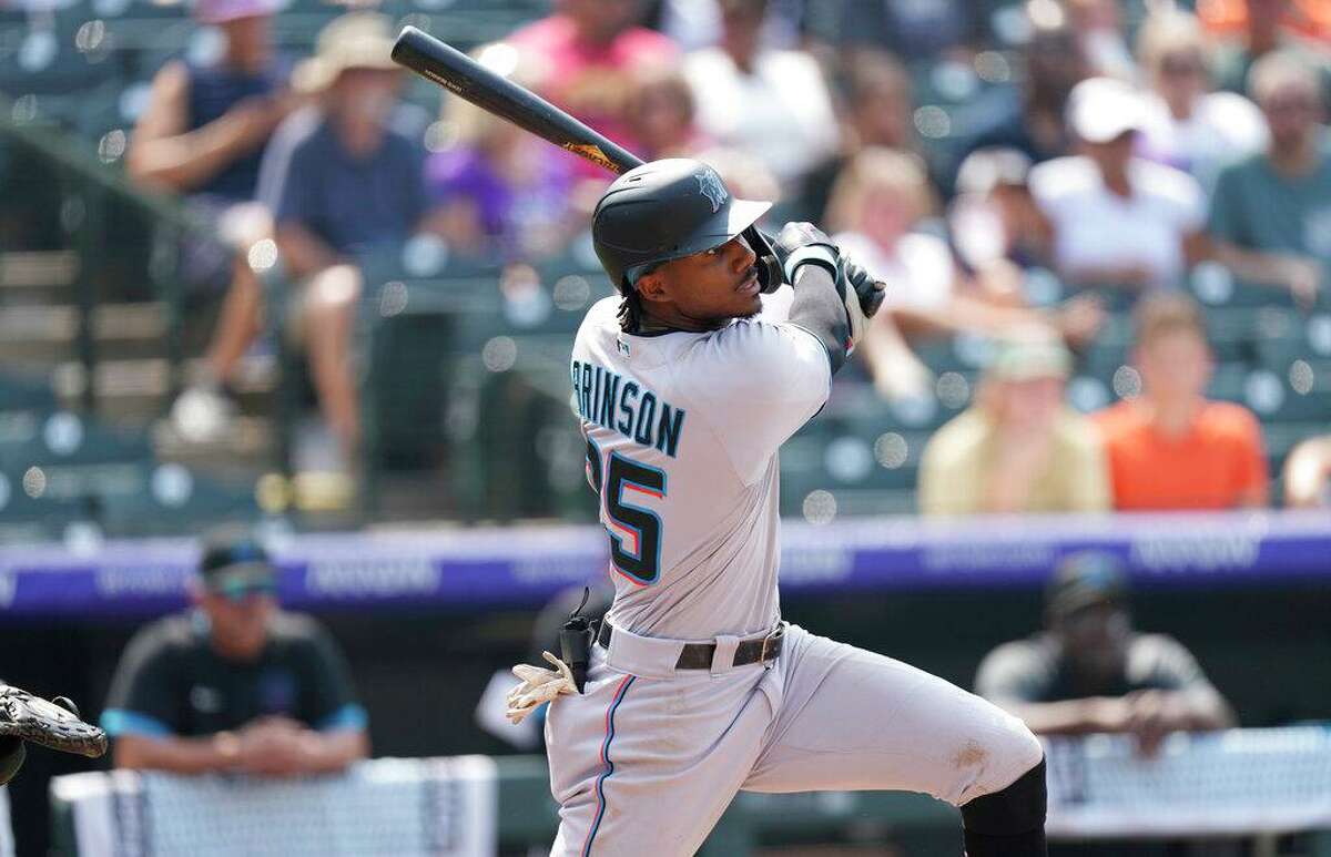 Miami Marlins' Lewis Brinson follows the flight of his double that drove in two runs off Colorado Rockies starting pitcher Kyle Freeland in the fifth inning of a baseball game Sunday, Aug. 8, 2021, in Denver. (AP Photo/David Zalubowski)