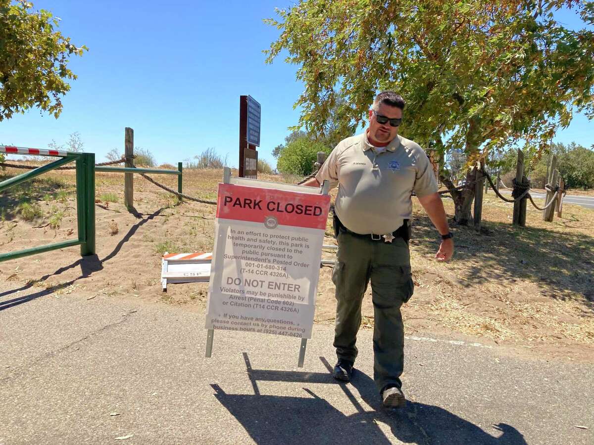 Ryen Goering puts on a "Parc Fermé" sign at the entrance road to Brannan Island.  Goering is superintendent of public safety for the Diablo Range District of the Department of Parks and Recreation.