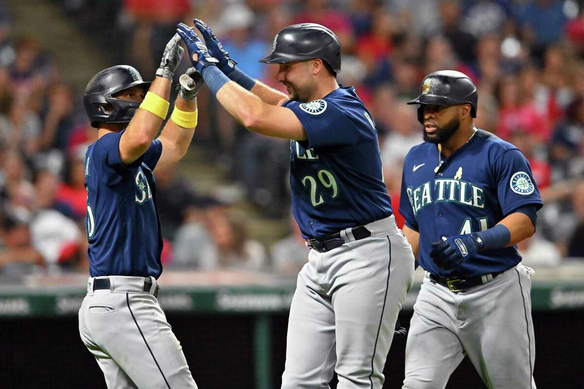 CLEVELAND, OHIO - SEPTEMBER 02: Adam Frazier #26 and Carlos Santana #41 of the Seattle Mariners celebrate with teammate Cal Raleigh #29 after they all scored on a home run by Raleigh during the sixth inning against the Cleveland Guardians at Progressive Field on September 02, 2022 in Cleveland, Ohio. (Photo by Jason Miller/Getty Images)