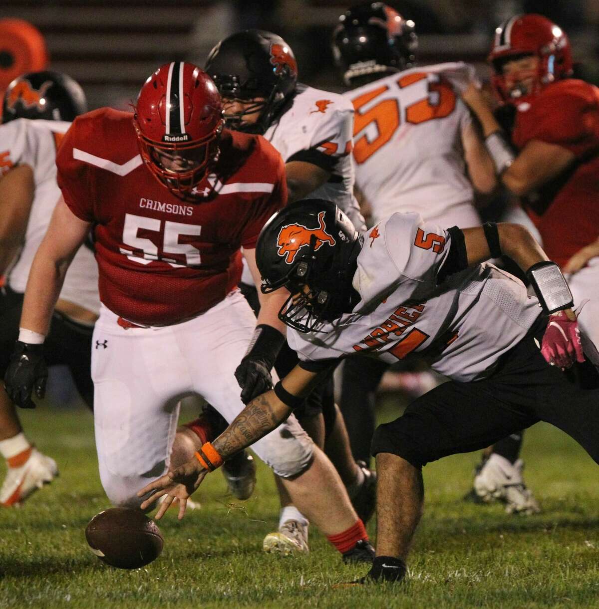 A Lanphier player reaches for a loose ball as Jacksonville's Ryan McCombs closes in during the second half of a football game at Jacksonville Friday night.