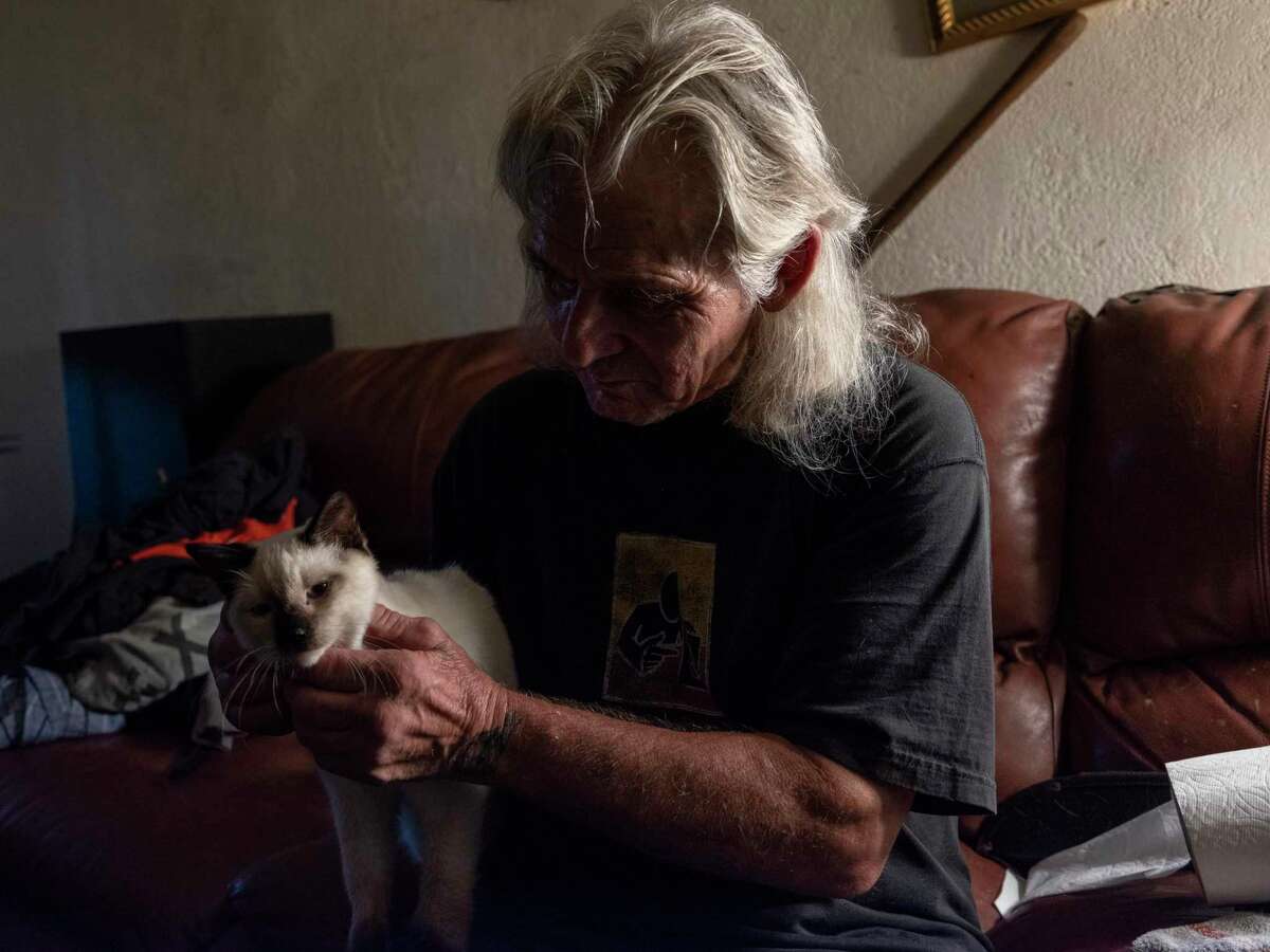 Earnest Hawkins pets his cat Simon at his apartment in Antioch.