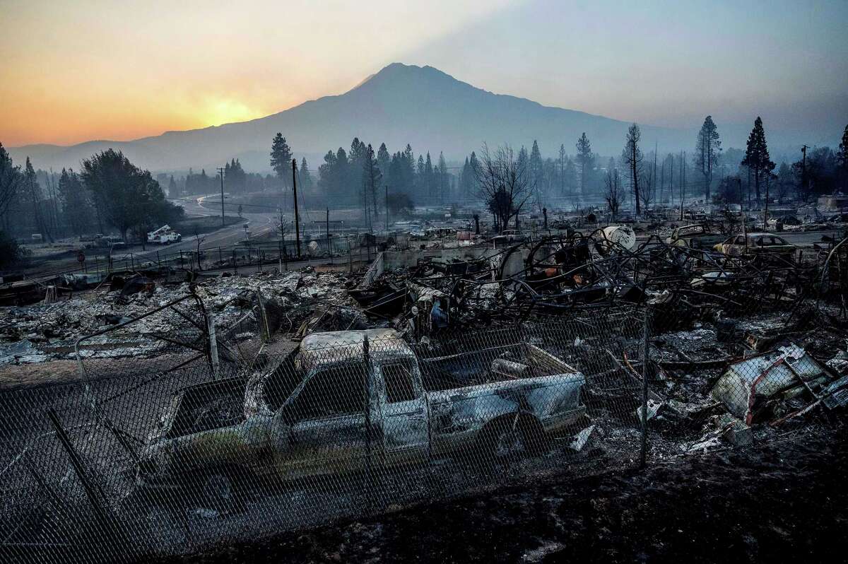 The sun rises over Mt. Shasta and homes destroyed by the Mill Fire on Saturday, Sept. 3, 2022, in Weed, Calif.