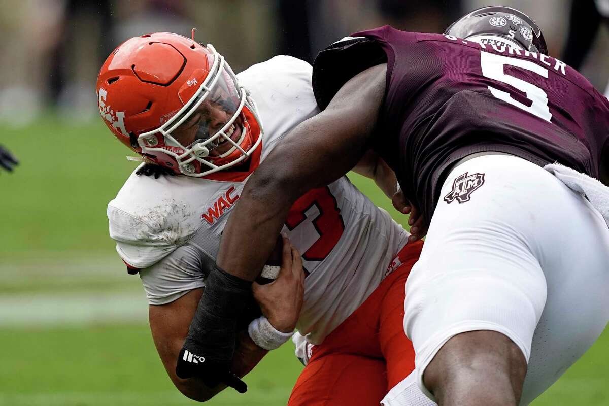 Sam Houston State quarterback Jordan Yates (13) is hit by Texas A&M defensive lineman Shemar Turner (5) during the first half of an NCAA college football game Saturday, Sept. 3, 2022, in College Station, Texas. (AP Photo/David J. Phillip)