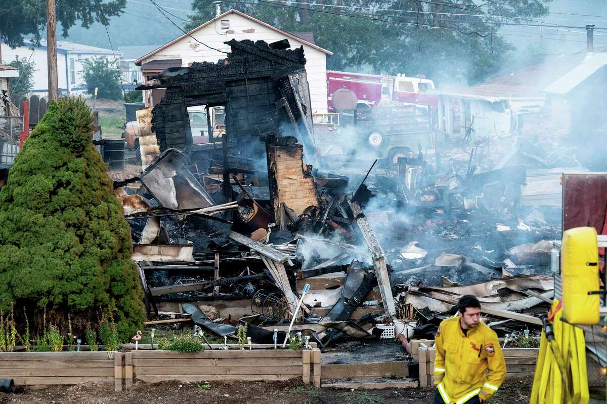 A firefighter passes a home destroyed by the Mill Fire on Saturday, Sept. 3, 2022, in Weed, Calif.
