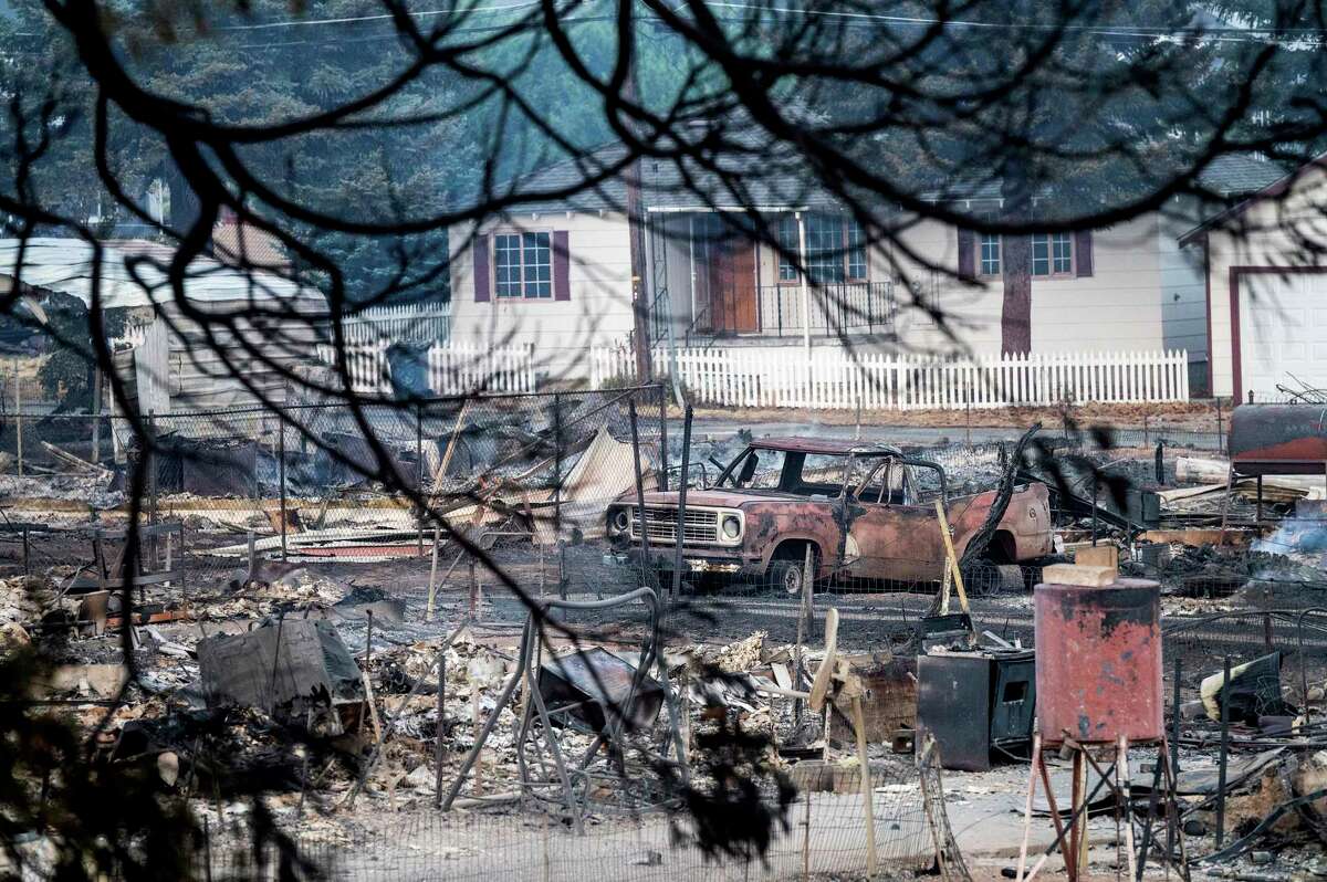 A vehicle rests amid homes leveled by the Mill Fire in Weed, Calif., on Saturday, Sept. 3, 2022.