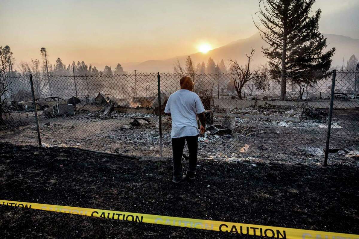 Dave Rodgers surveys his home, destroyed by the Mill Fire, on Saturday, Sept. 3, 2022, in Weed, Calif. Rodgers, who lived in the house his entire life, was able to take an elderly neighbor with him as he fled the fast-moving blaze but has not been able to find his two dogs that were left behind.