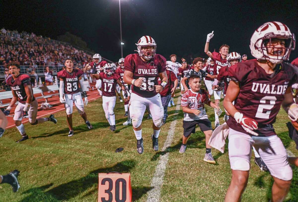 Armando Luna (65) and his Uvalde High school teammates celebrate by beating Eagle Pass Winn, 34-28, in their first home game since May 24, when 21 students and teachers were gunned down at Robb Elementary School of Uvalde.