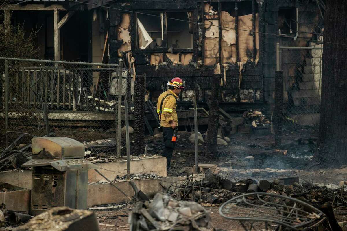 A firefighter walks among homes burned by the Mill Fire in Weed (Siskiyou County). The entire town, which is about 50 miles from the Oregon border, is under evacuation orders.