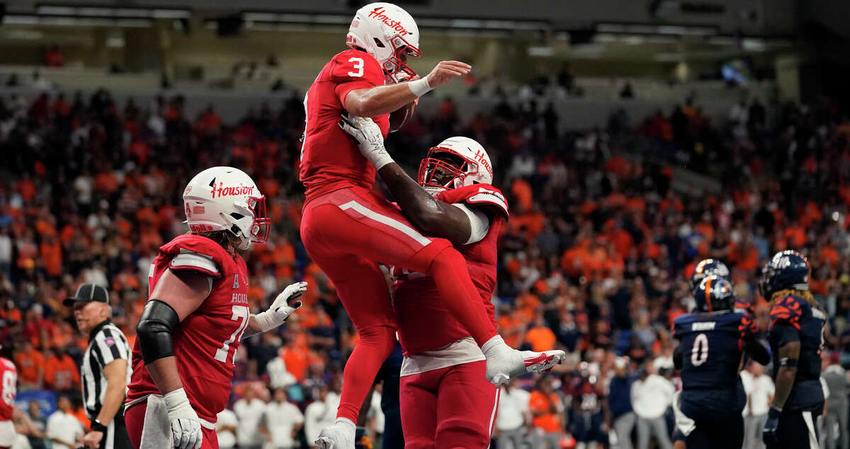 Houston quarterback Clayton Tune (3) is lifted by teammate Houston offensive lineman Patrick Paul (76) after his touchdown run against UTSA during overtime in an NCAA college football game, Saturday, Sept. 3, 2022, in San Antonio. (AP Photo/Eric Gay)