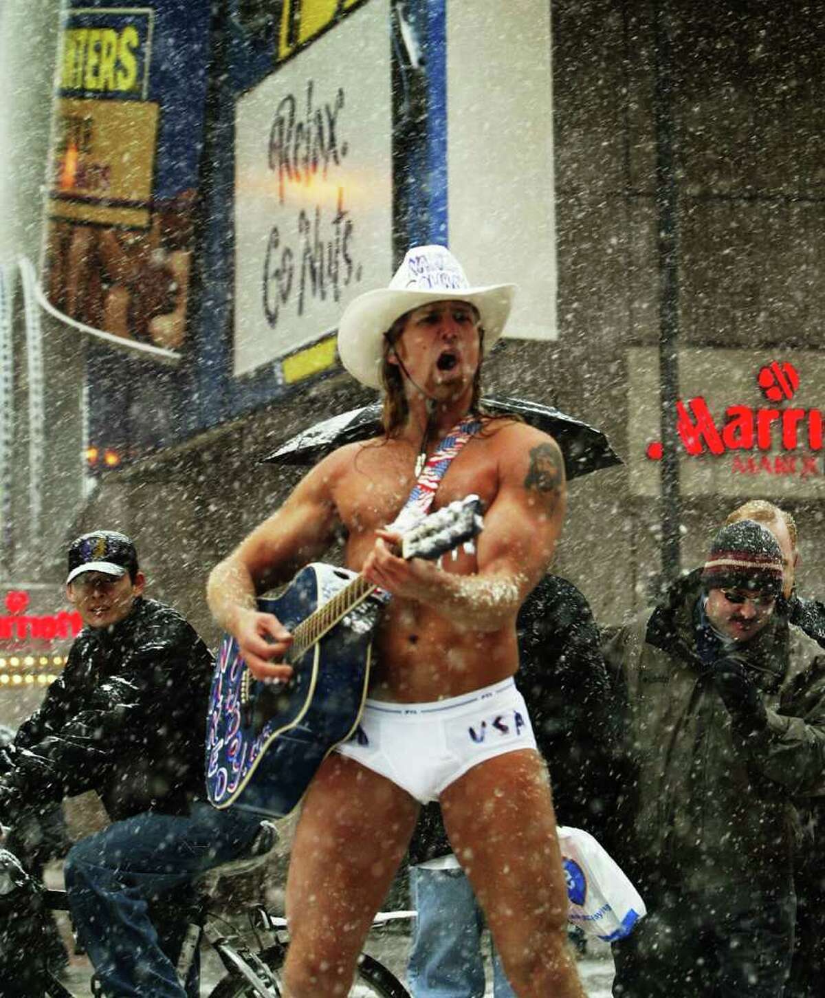 NEW YORK - DECEMBER 5: Robert John Burck, who calls himself "The Naked Cowboy" plays his guitar in Times Square December 5, 2002 in New York City. New York City may get up to eight inches of snow in an early East Coast storm that has closed schools throughout the area and left six people dead in traffic accidents. (Photo by Robert Giroux/Getty Images)