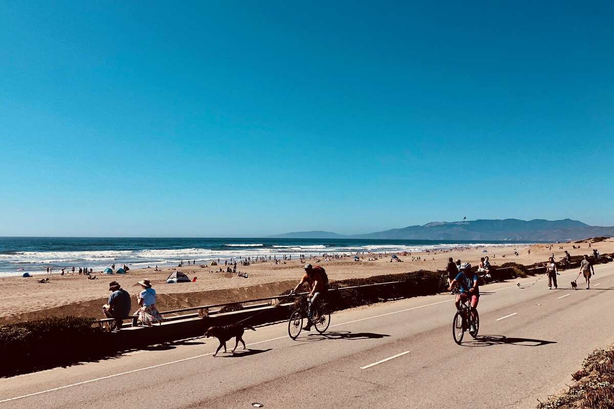 People bike the Great Highway amid sunny skies at Ocean Beach, on Sunday, Sept. 4, 2022.