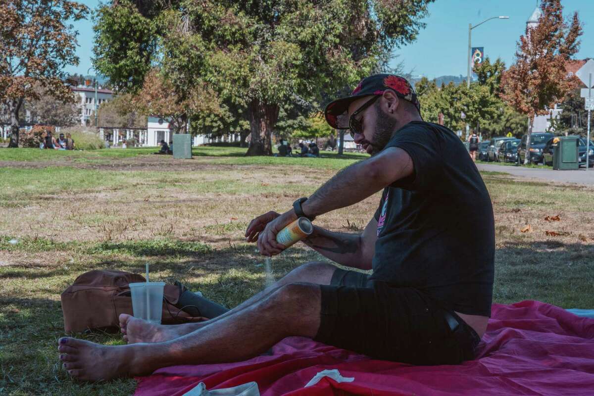 Ken Manning applies sunscreen near Oakland’s Lake Merritt on Saturday.