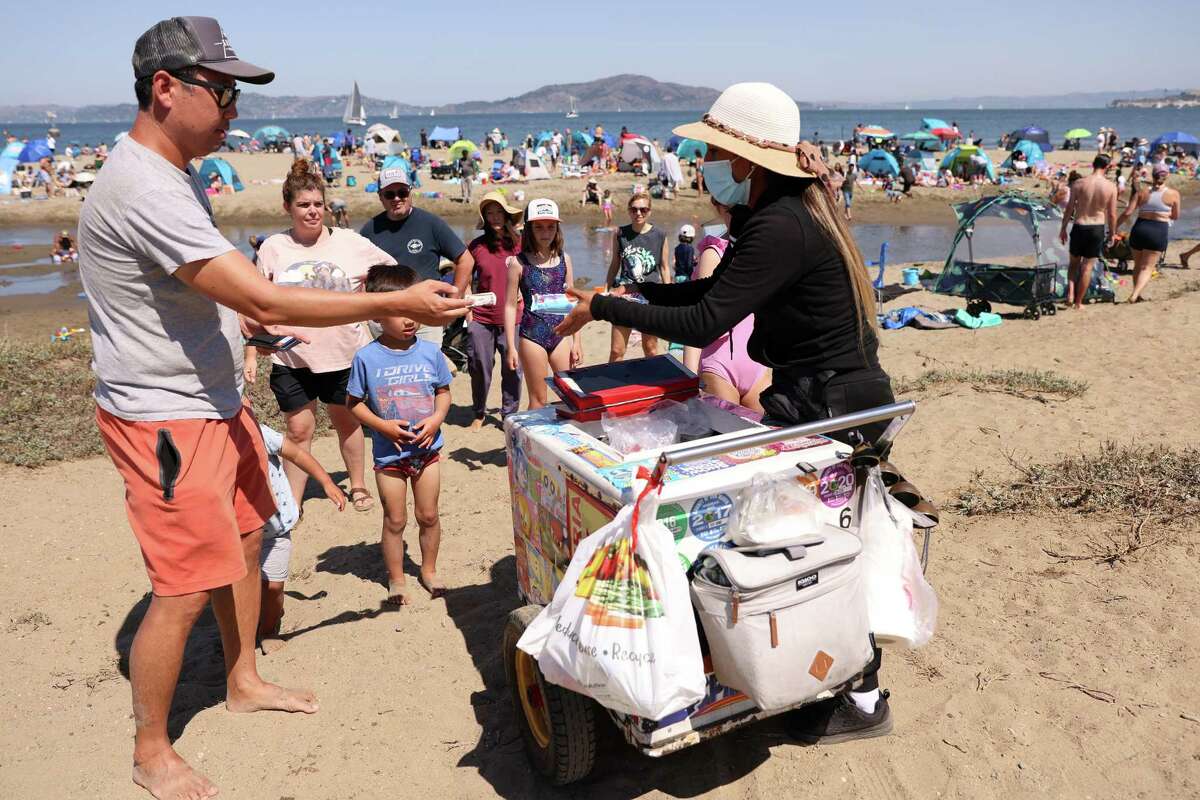 周一，在旧金山的Crissy Field，一名冰淇淋小贩向海滩游客出售冷饮。