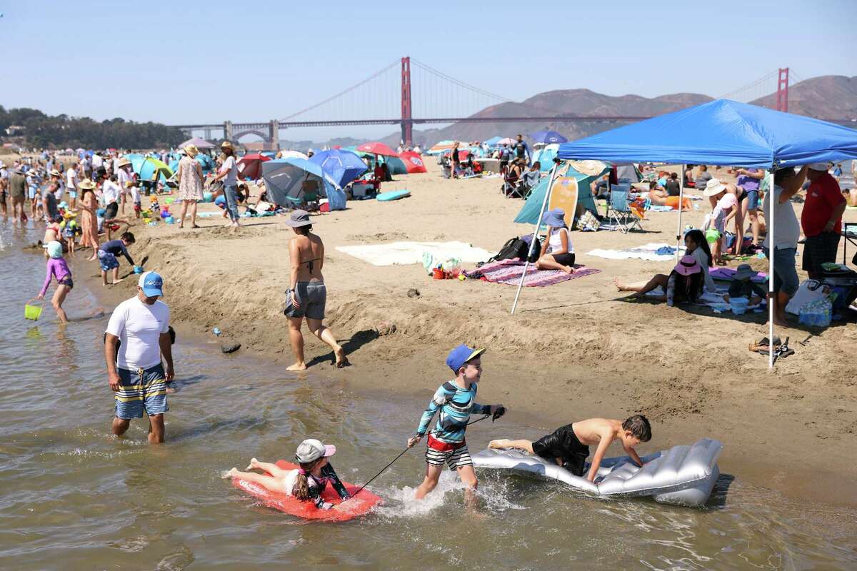 As temperatures rise, children play in the water at Crissy Field in San Francisco on Monday.